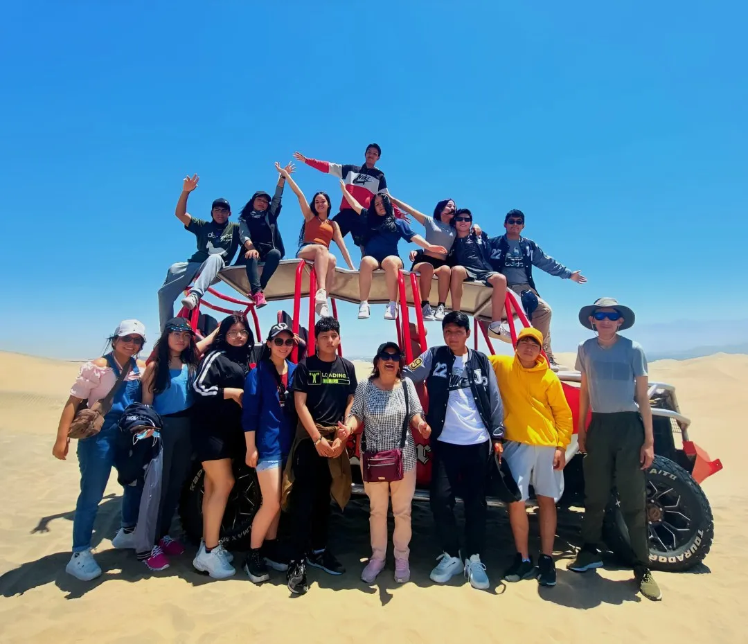 Grupo de alumnos sobre un tubular en las dunas de Ica